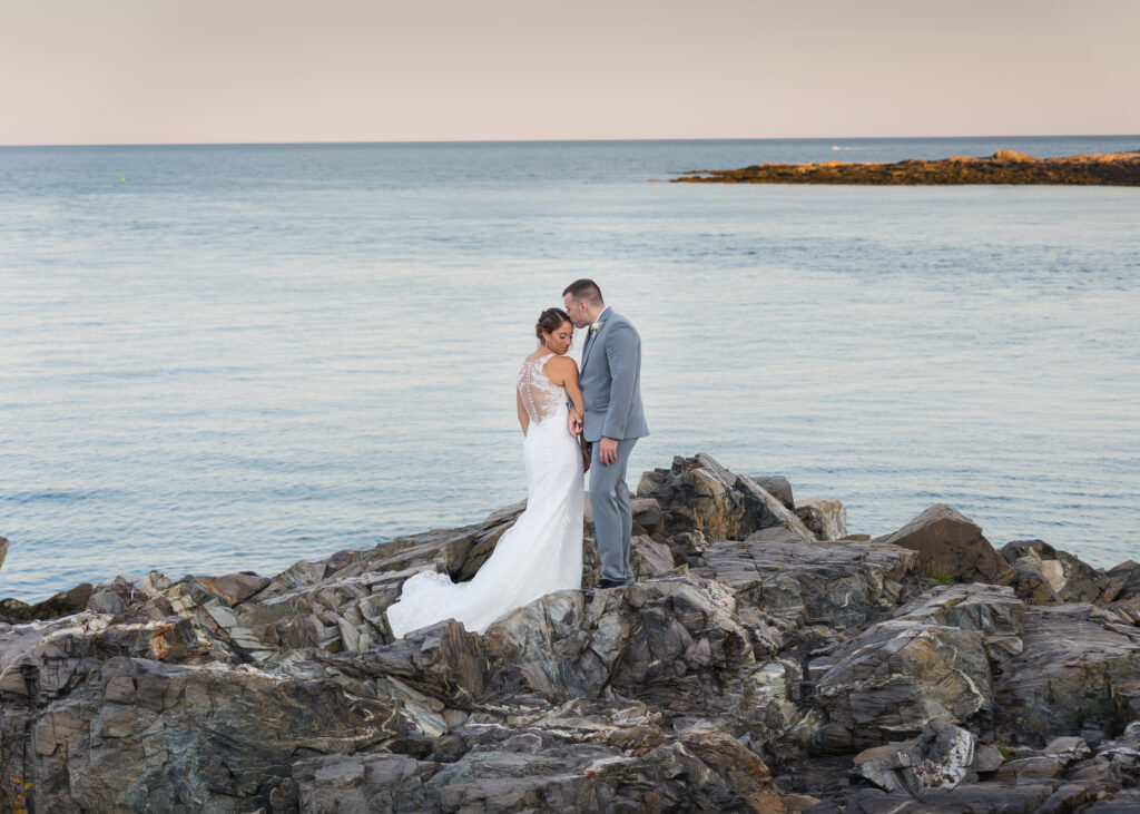 Bride and groom standing near the ocean